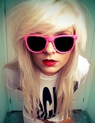 Średniej długości, blond emo fryzurka z gęstą grzywką